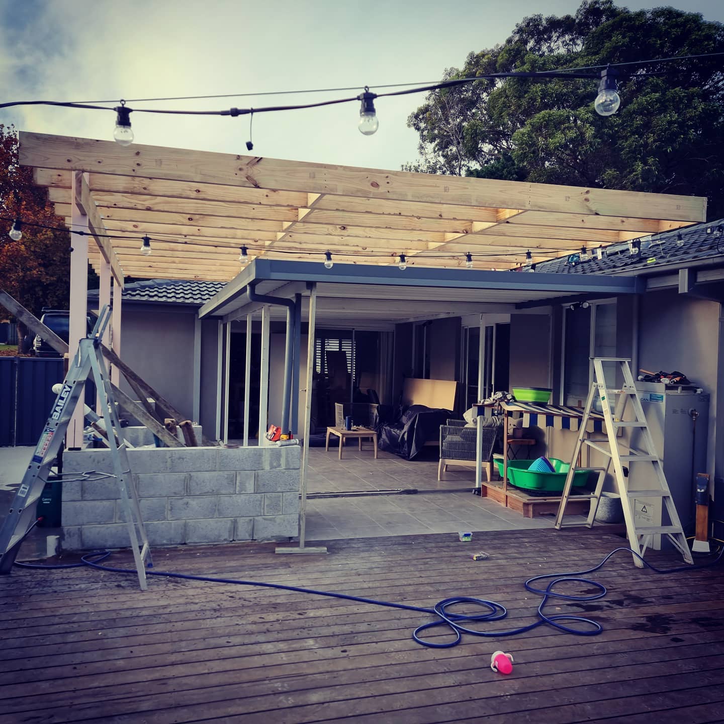 Timber pergola under construction over paved patio
