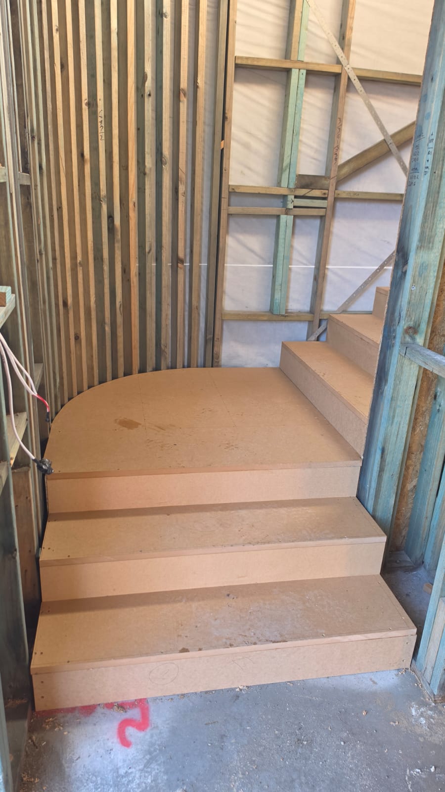 Curved bullnose bottom step and lower flight of a timber staircase built in a Blue Bay townhouse
