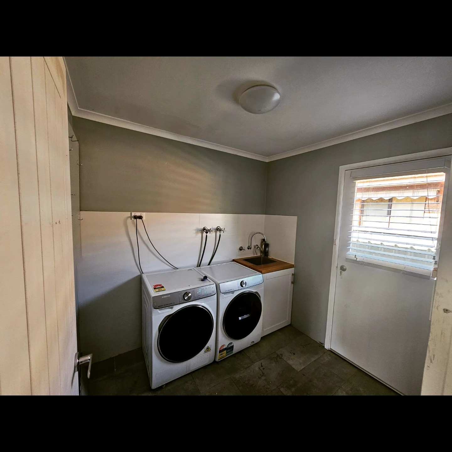 Laundry renovation with new tiling, sink and cabinetry
