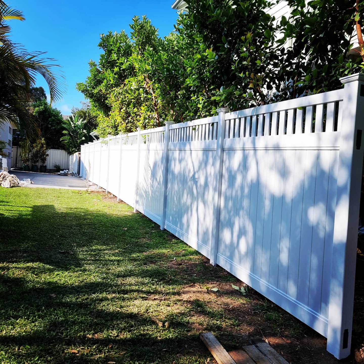 White picket-top privacy fence in a backyard