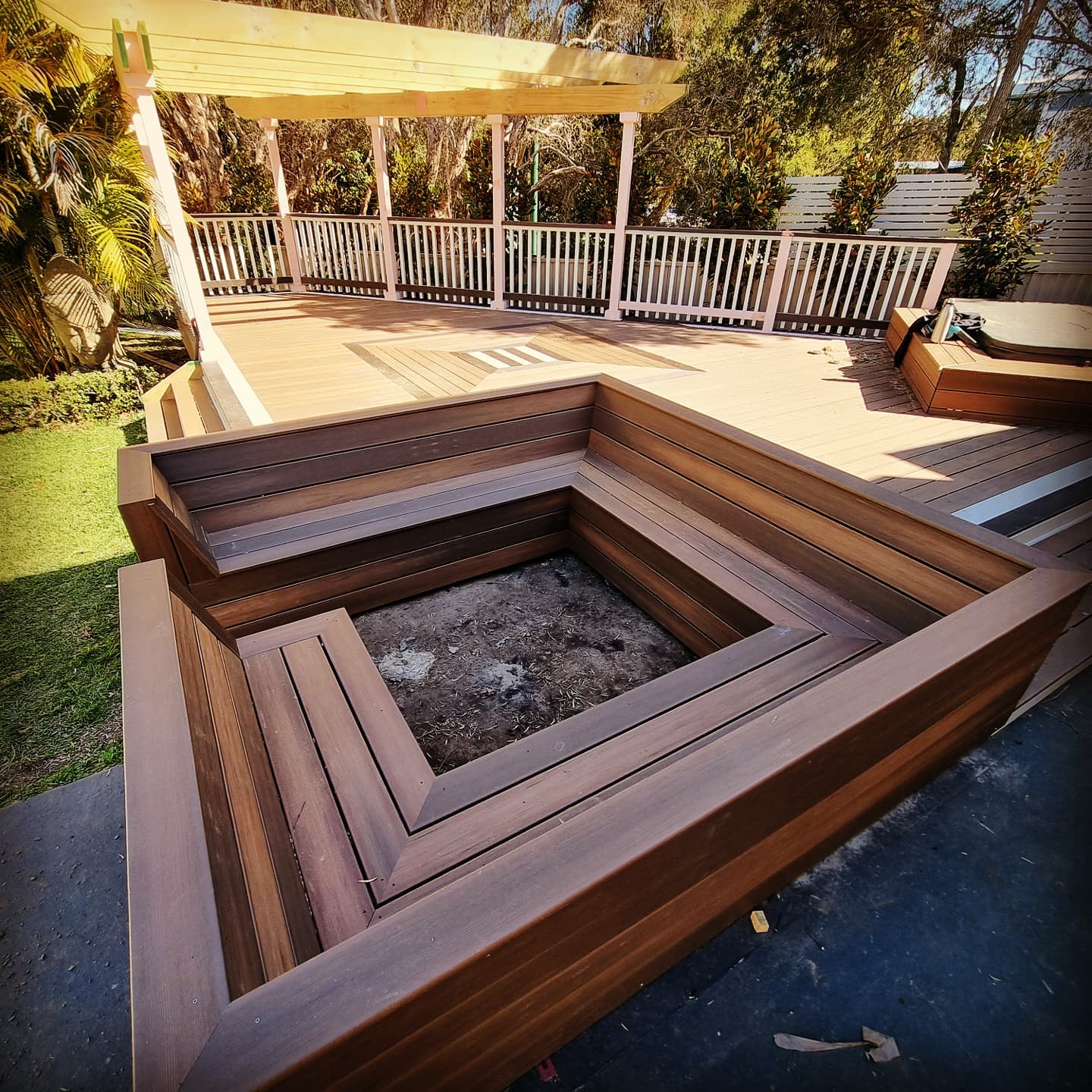 Composite deck with built-in firepit surround and pergola